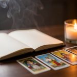 Table apaisante et élégante avec un carnet ouvert, des cartes disposées et une bougie douce, dans une atmosphère spirituelle chaleureuse.